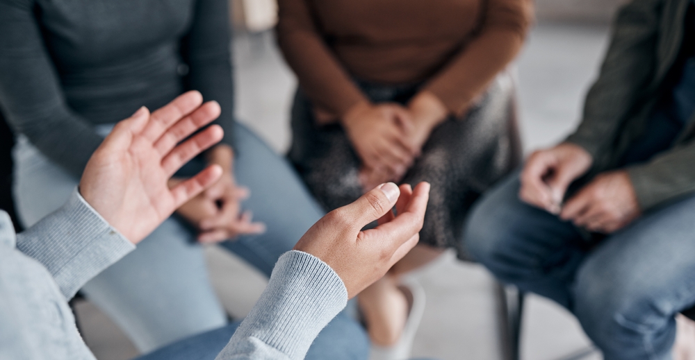 womans hands in group therapy session for physicians